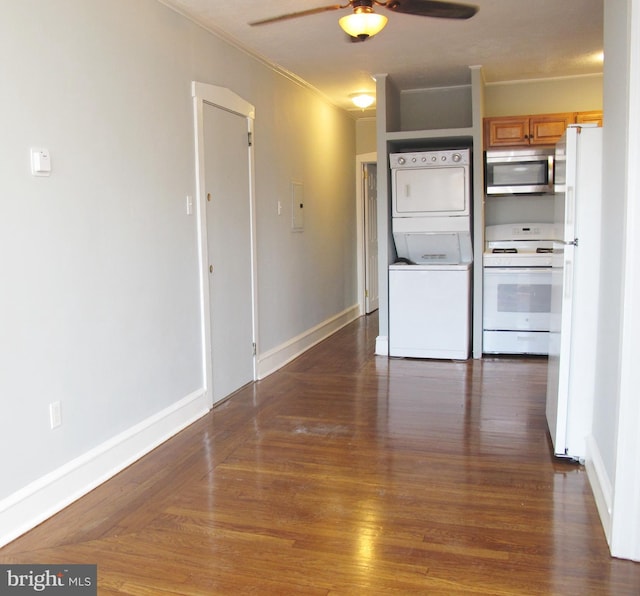 kitchen featuring white appliances, stacked washing maching and dryer, ceiling fan, ornamental molding, and dark hardwood / wood-style flooring