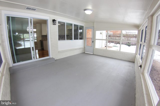 unfurnished sunroom featuring vaulted ceiling