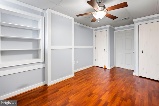 unfurnished bedroom with wood finished floors, a ceiling fan, baseboards, visible vents, and multiple closets