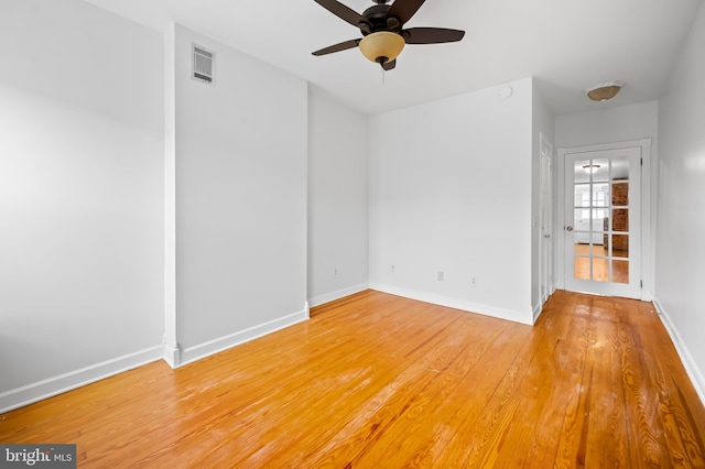 unfurnished room featuring ceiling fan, light wood finished floors, visible vents, and baseboards