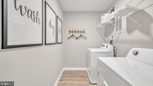 washroom with light wood-type flooring and washing machine and clothes dryer