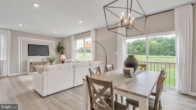 dining room with light hardwood / wood-style floors and a chandelier