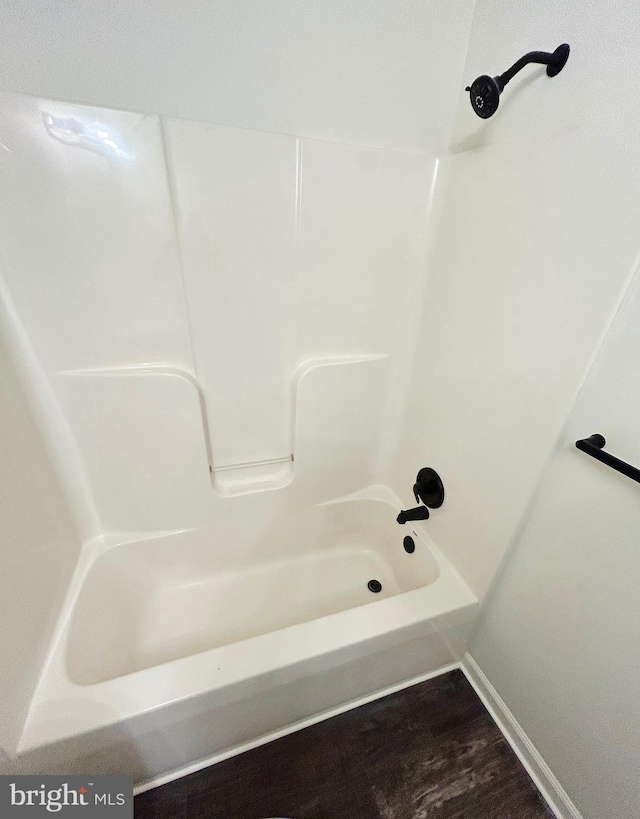 full bath featuring bathing tub / shower combination and wood finished floors