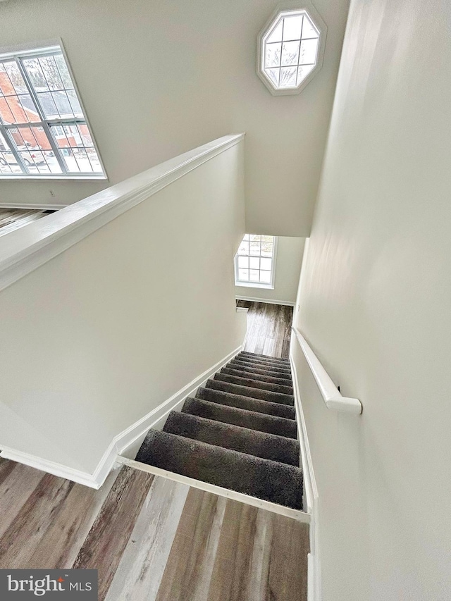 stairway featuring baseboards and wood finished floors