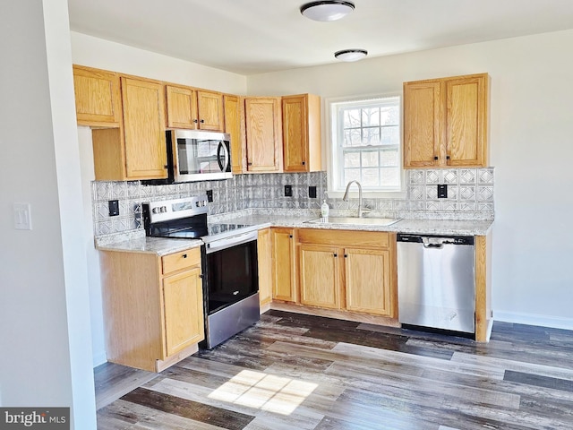 kitchen featuring a sink, dark wood-style floors, backsplash, and stainless steel appliances