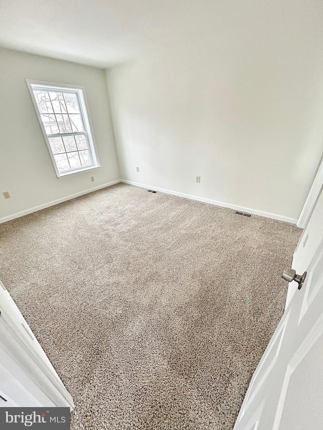 unfurnished room featuring visible vents, baseboards, and carpet flooring