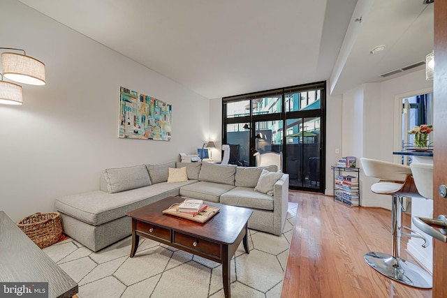 living area with light wood-style floors and floor to ceiling windows