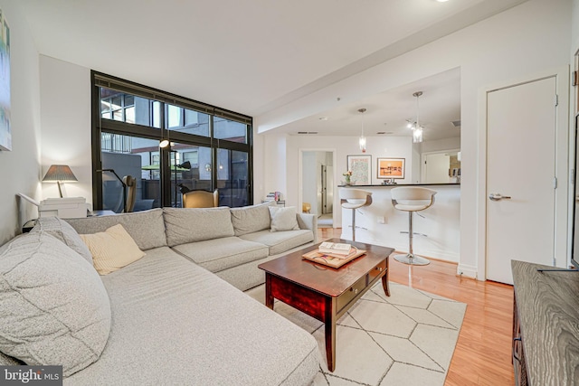 living area with light wood-type flooring, baseboards, and floor to ceiling windows