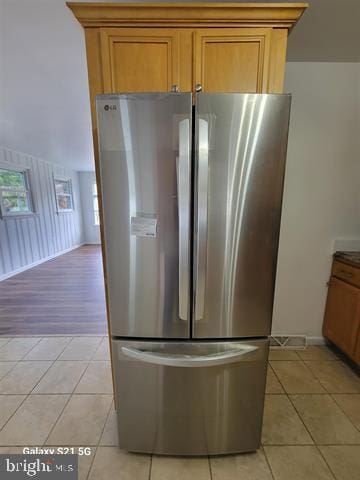 kitchen featuring light tile patterned floors and stainless steel refrigerator