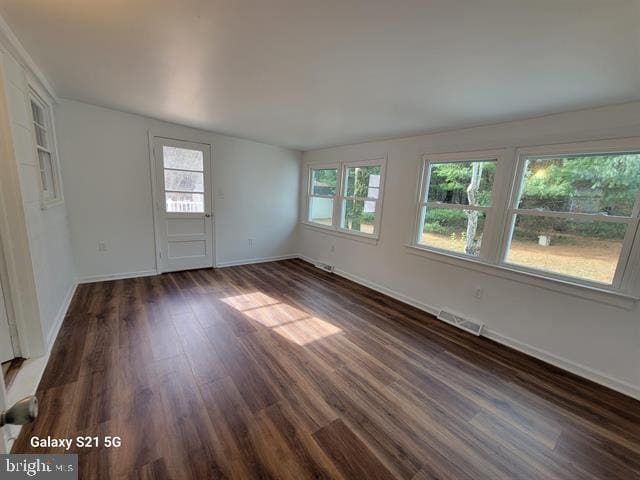 unfurnished room featuring lofted ceiling and dark hardwood / wood-style floors