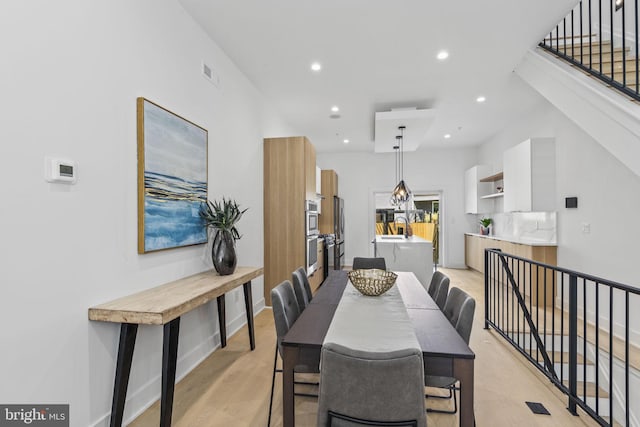 dining room featuring light wood-type flooring and sink