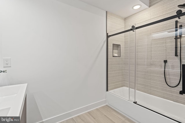 bathroom featuring bath / shower combo with glass door and vanity