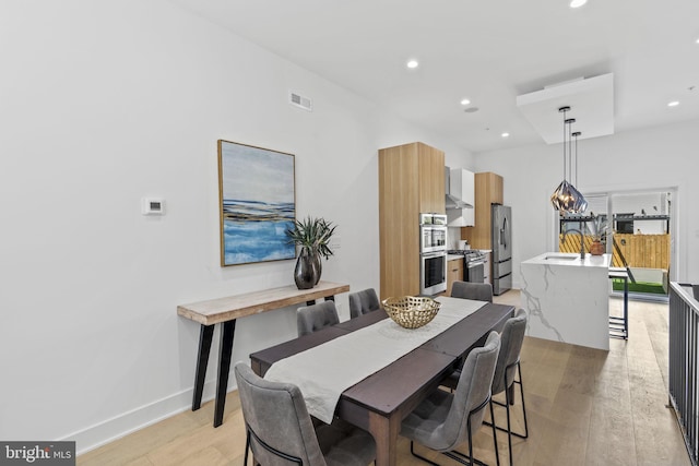 dining space with light hardwood / wood-style floors and sink