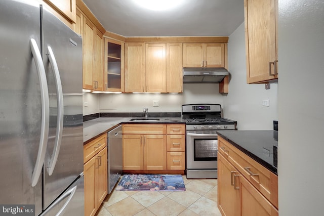 kitchen featuring light tile patterned floors, sink, dark stone counters, and appliances with stainless steel finishes