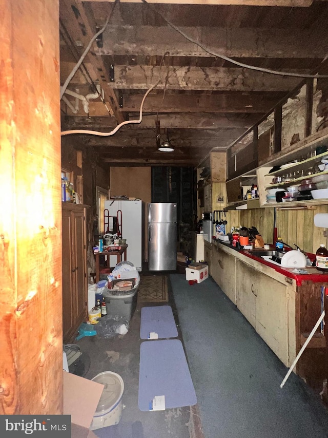 basement with stainless steel fridge and white refrigerator