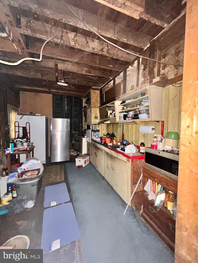 basement with stainless steel refrigerator and white refrigerator