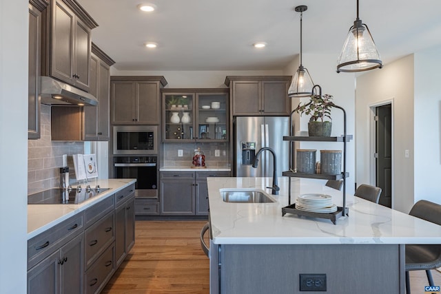 kitchen with sink, stainless steel appliances, decorative light fixtures, and decorative backsplash