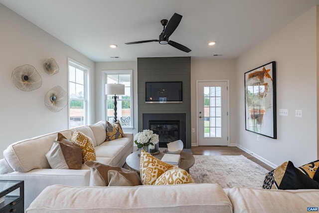 living room with a fireplace, ceiling fan, and hardwood / wood-style floors