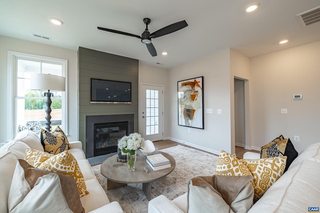 living room featuring a fireplace, ceiling fan, and hardwood / wood-style floors