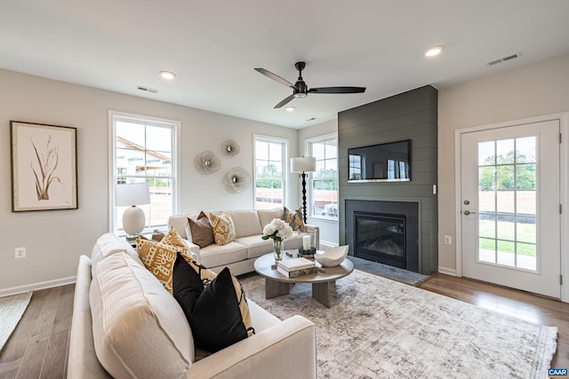 living room with a large fireplace, ceiling fan, and hardwood / wood-style floors