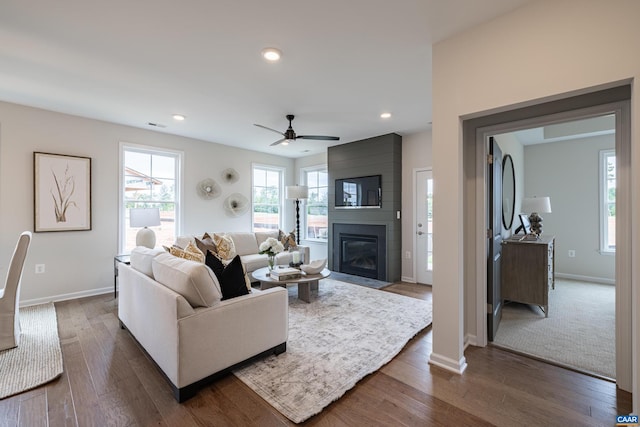 living room with a fireplace, ceiling fan, and dark hardwood / wood-style floors