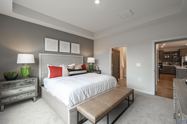 carpeted bedroom with a raised ceiling and stainless steel fridge