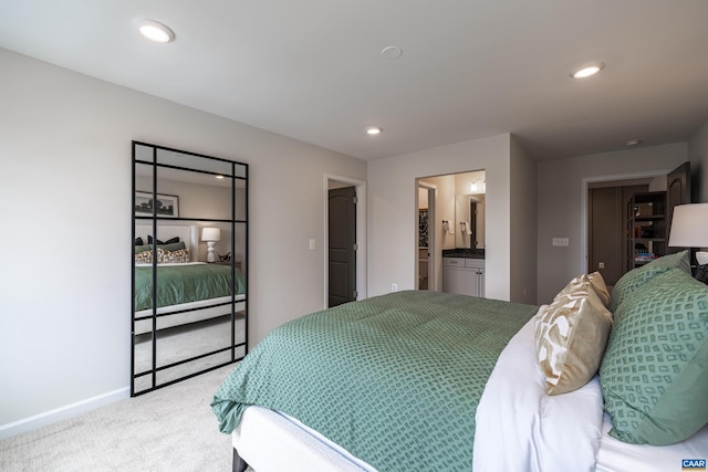 bedroom with connected bathroom and carpet flooring