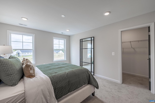 carpeted bedroom with a closet and a spacious closet