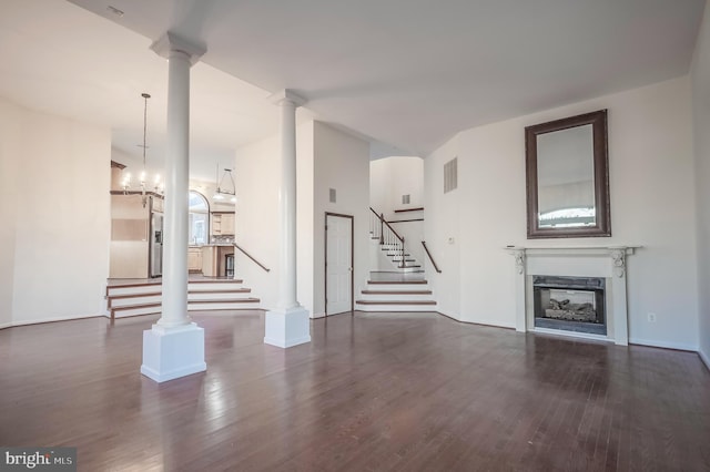 unfurnished living room featuring dark wood-type flooring and a notable chandelier