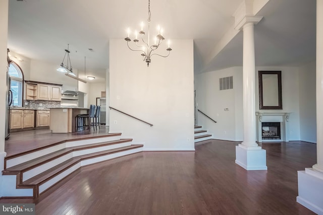 unfurnished living room featuring dark hardwood / wood-style flooring and an inviting chandelier