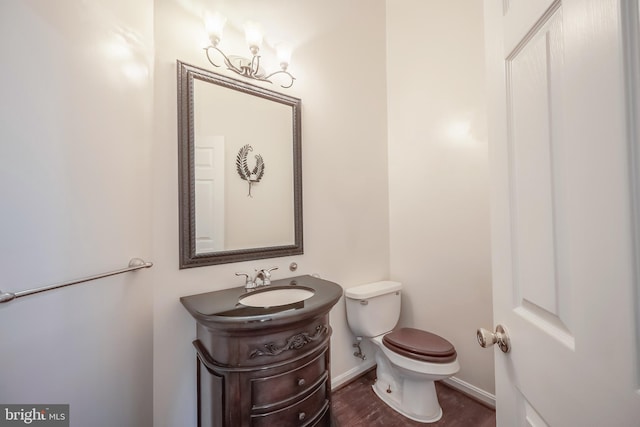 bathroom with hardwood / wood-style floors, toilet, and vanity