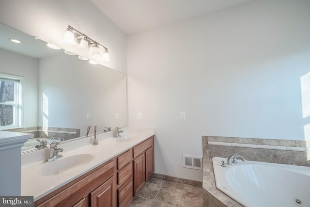 bathroom with tiled bath and vanity