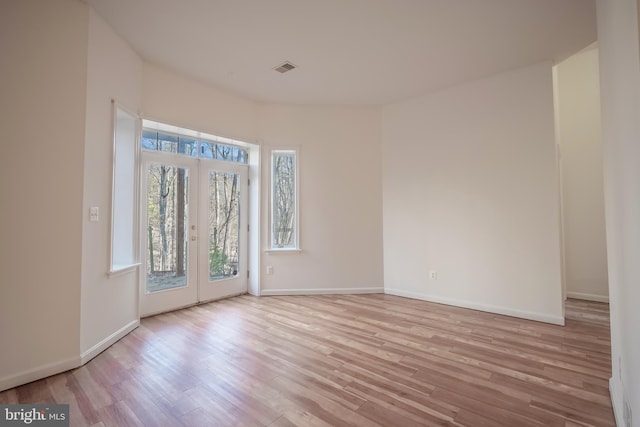 empty room with french doors and light hardwood / wood-style floors