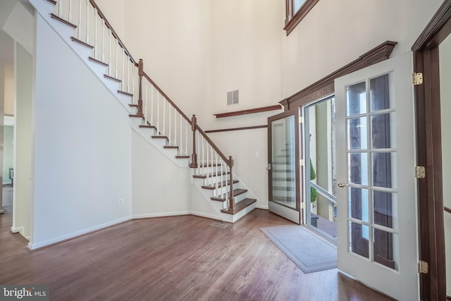 foyer entrance with hardwood / wood-style flooring, french doors, and a high ceiling