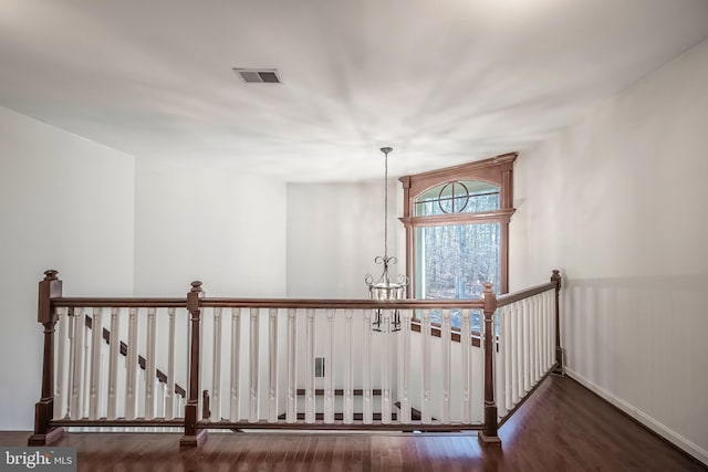 staircase featuring a chandelier and hardwood / wood-style flooring