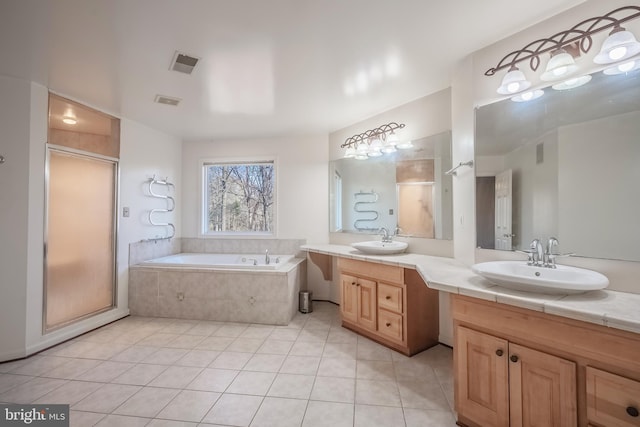 bathroom with tile patterned floors, vanity, and shower with separate bathtub