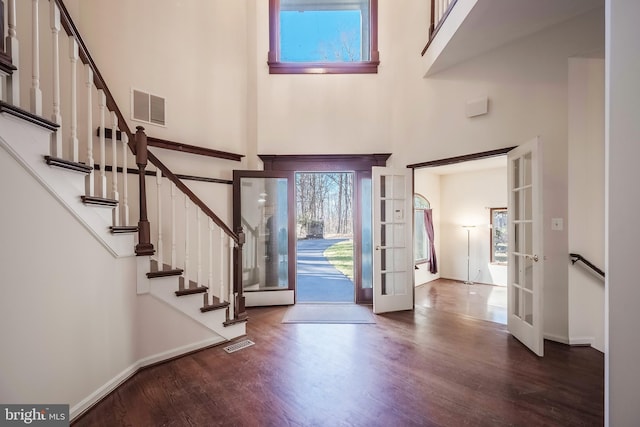 entrance foyer with a high ceiling, dark hardwood / wood-style floors, and french doors