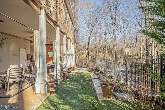 view of yard with ceiling fan and a patio area