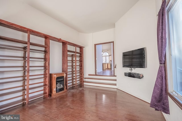 unfurnished living room featuring hardwood / wood-style floors and heating unit