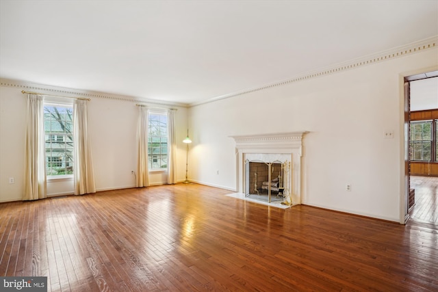 unfurnished living room with a premium fireplace, crown molding, and hardwood / wood-style floors