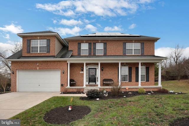 view of front of home featuring a front yard, a garage, a porch, and solar panels