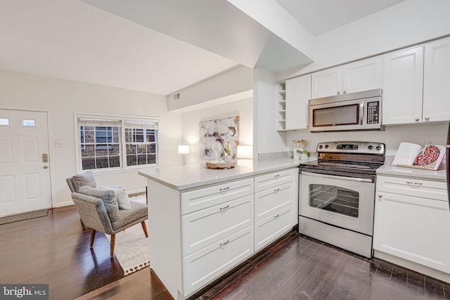 kitchen featuring dark wood-style floors, appliances with stainless steel finishes, light stone counters, a peninsula, and white cabinetry