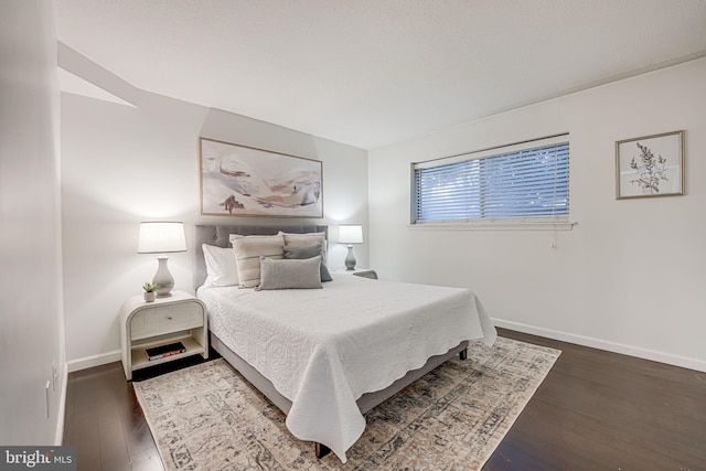 bedroom with baseboards and wood finished floors