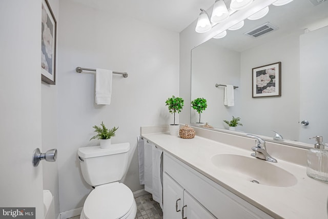 bathroom with toilet, vanity, visible vents, and baseboards