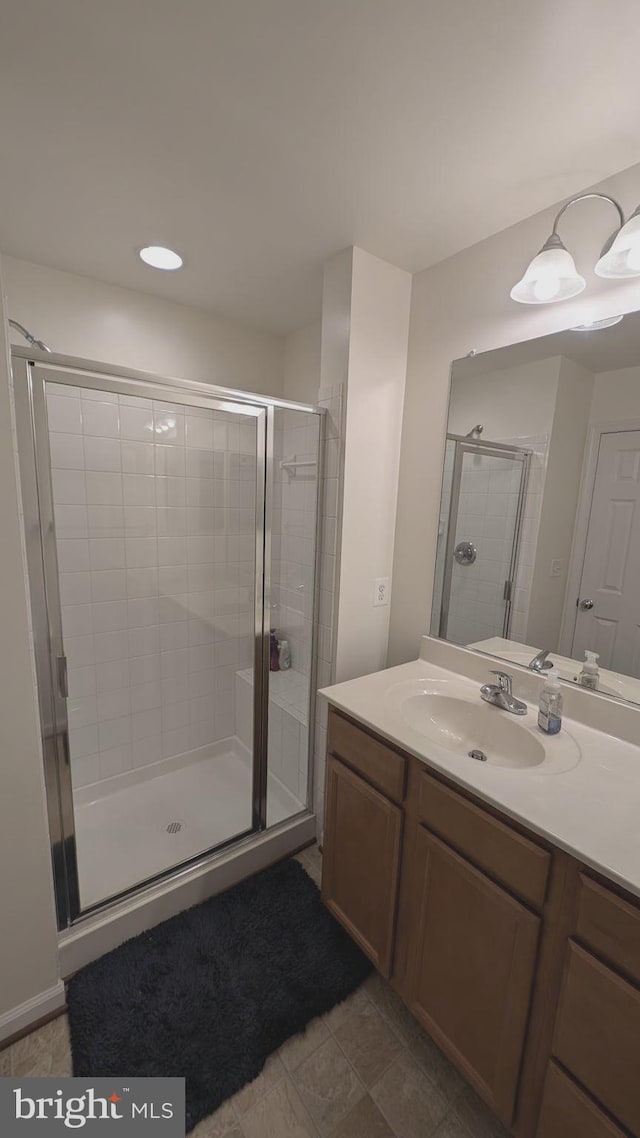 bathroom featuring a shower with door, tile patterned flooring, and vanity