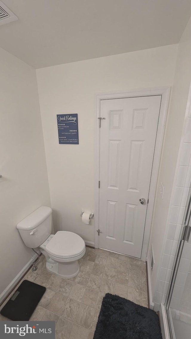 bathroom featuring toilet and an enclosed shower