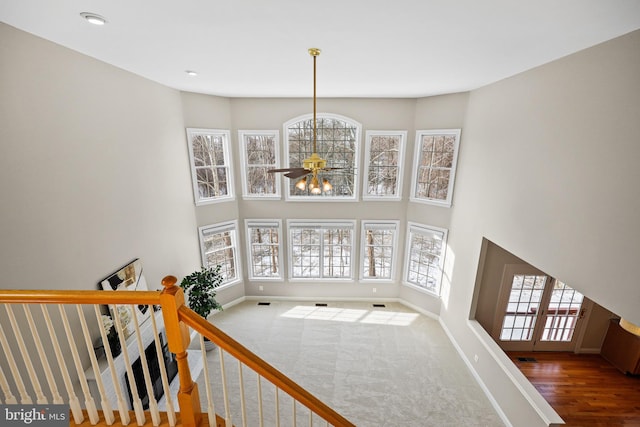 interior space with ceiling fan, carpet, and a high ceiling