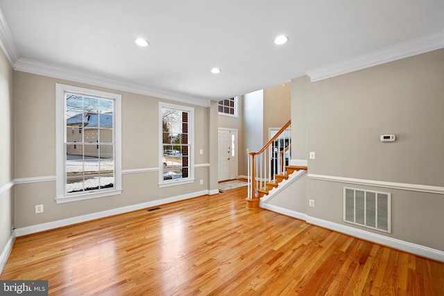 foyer featuring ornamental molding and light wood-type flooring