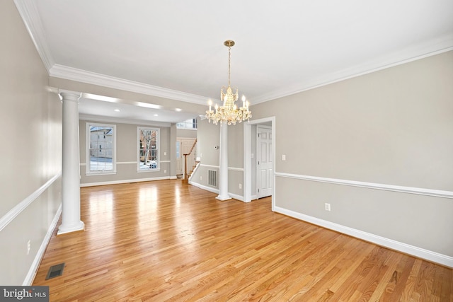 unfurnished dining area featuring a notable chandelier, crown molding, light hardwood / wood-style flooring, and ornate columns