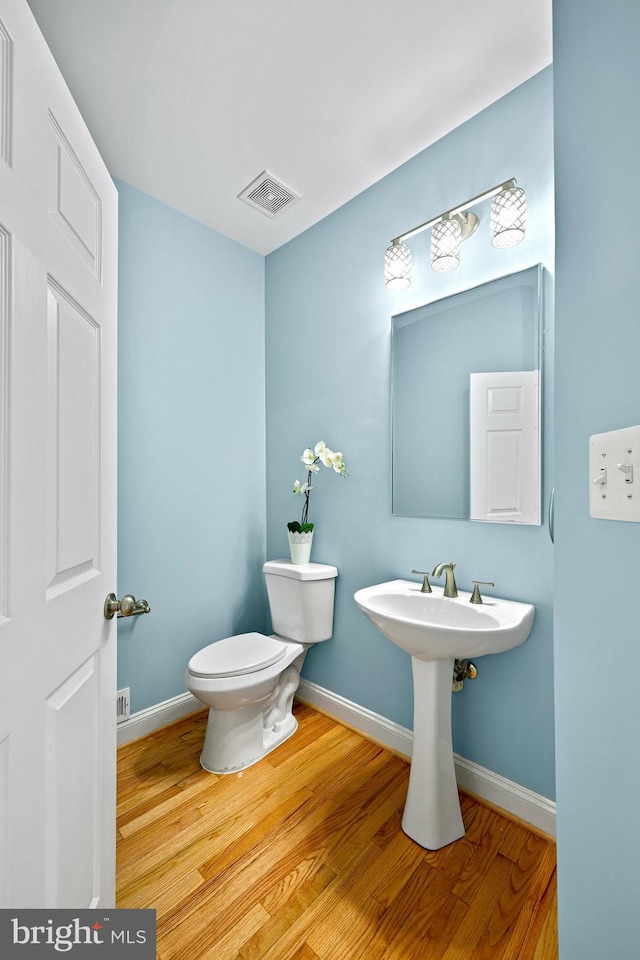 bathroom with hardwood / wood-style flooring and toilet